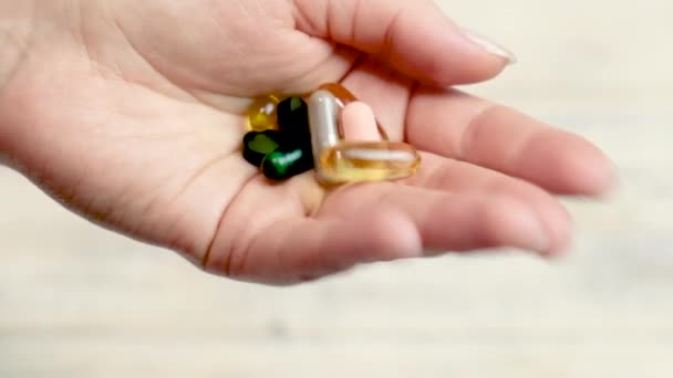 Différentes pilules à la main, des compléments alimentaires. focus sélectif — Video