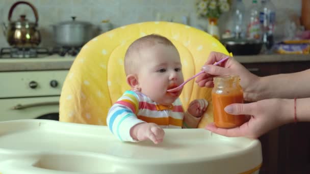 Kleine moeder baby voedt puree fruit groenten. selectieve focus — Stockvideo