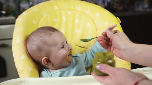 Petite mère bébé nourrit purée fruits légumes. focus sélectif — Video