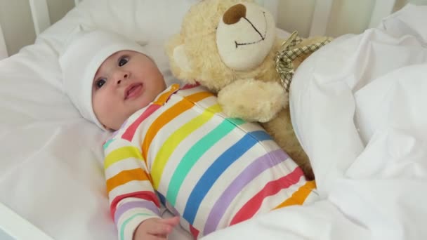 Baby spielt vor dem Schlafengehen mit Teddybär Selektiver Fokus. — Stockvideo