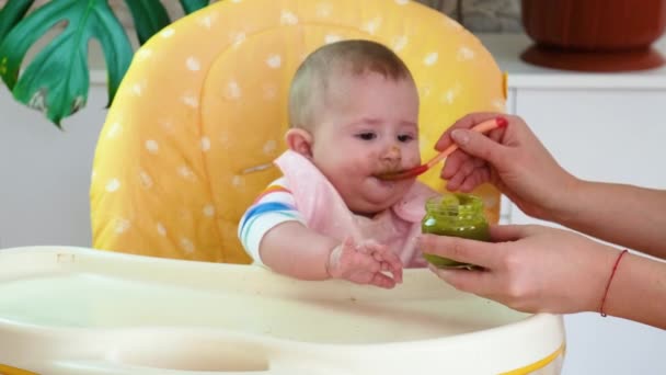 Lilla mor baby matar puré frukt grönsaker. selektivt fokus — Stockvideo