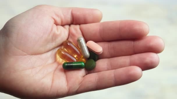 Διαφορετικά χάπια στο χέρι, συμπληρώματα διατροφής. επιλεκτική εστίαση — Αρχείο Βίντεο