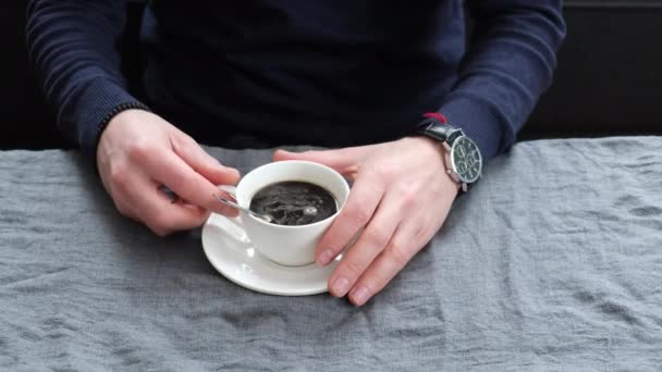Muž pije kávu u stolu. selektivní zaměření. — Stock video