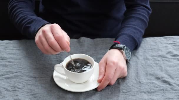 Man dricker kaffe vid bordet. selektivt fokus. — Stockvideo