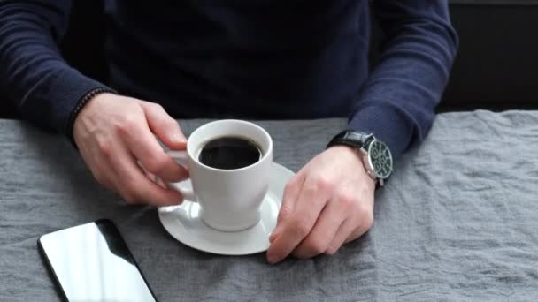 Man dricker kaffe vid bordet. selektivt fokus. — Stockvideo