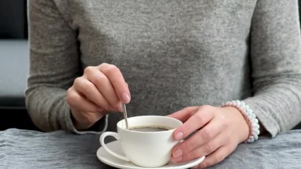 Μια γυναίκα που πίνει καφέ στο τραπέζι. επιλεκτική εστίαση. — Αρχείο Βίντεο