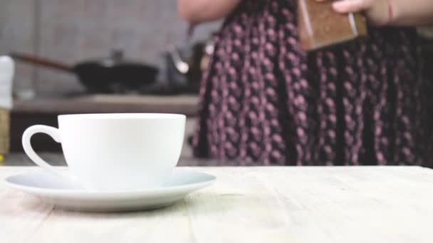 Eine Frau gießt Instant-Kaffee in eine Tasse. Selektiver Fokus. — Stockvideo