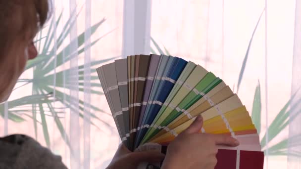 Kobieta wybiera kolor farby na palecie do naprawy. Skupienie selektywne. — Wideo stockowe