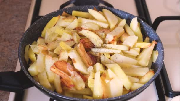 Potatisen är stekt på spisen och peppar. Selektiv inriktning. — Stockvideo