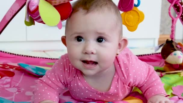 赤ん坊の女の子は子供のラグのおもちゃで再生されます。選択的焦点. — ストック動画