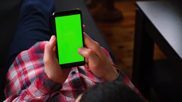 Man with a phone in his hands, green screen. Selective focus. — Stock Video