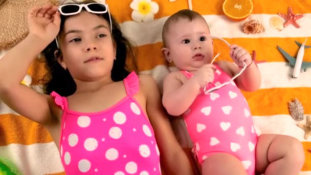 Enfants sœurs bronzer sur la plage. focus sélectif. — Video