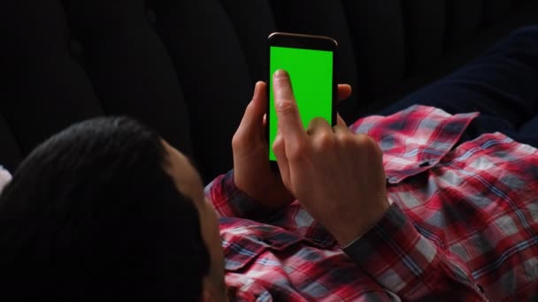 Man with a phone in his hands, green screen. Selective focus. — Stock Video