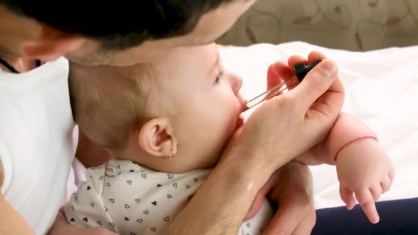 O pequeno pai bebé dá medicamentos. foco seletivo. — Vídeo de Stock