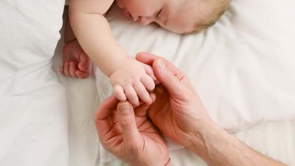 小さな赤ん坊の眠っている父は手で与えます。選択的焦点. — ストック動画