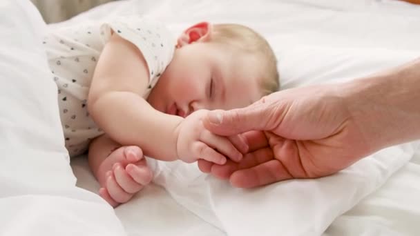 Kleine baby slapende vader geeft door de hand. selectieve focus. — Stockvideo