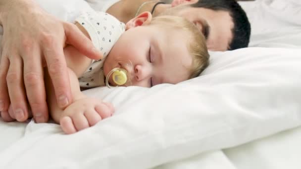 お父さんは赤ん坊をベッドに置く。選択的焦点. — ストック動画
