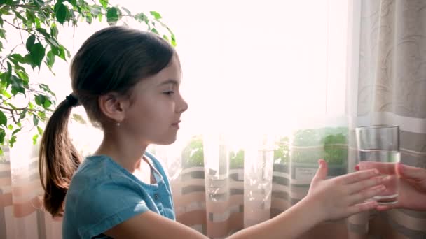 Das Kind trinkt Wasser aus einem Glas. Selektiver Fokus. — Stockvideo