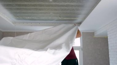 İşçiler odanın tavanını gerer. seçici odak.