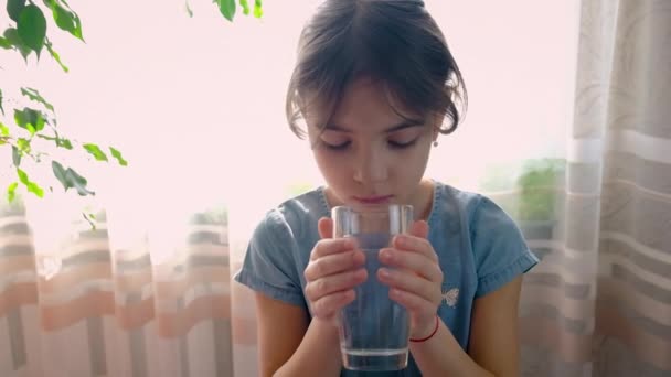 Il bambino beve acqua da un bicchiere. Focus selettivo. — Video Stock