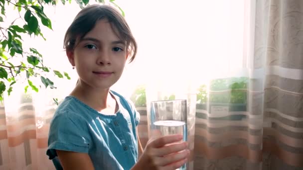 Das Kind trinkt Wasser aus einem Glas. Selektiver Fokus. — Stockvideo