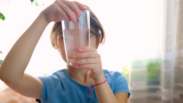 Das Kind blickt in einem Glas auf das Wasser. Selektiver Fokus. — Stockvideo