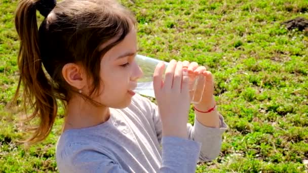 Дитина п'є воду зі склянки. Вибірковий фокус . — стокове відео
