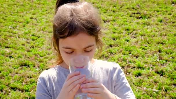 子供はガラスから水を飲む。選択的焦点. — ストック動画