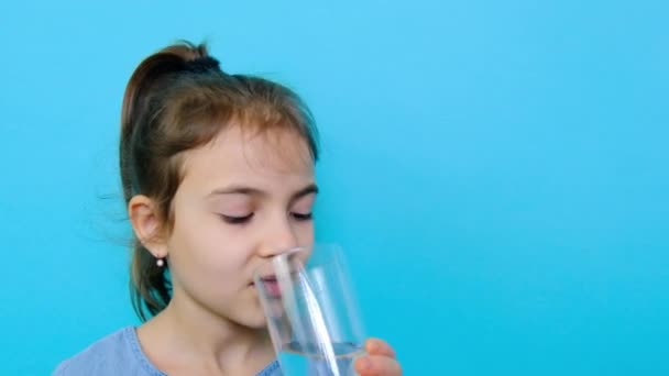 Das Kind trinkt Wasser aus einem Glas. Selektiver Fokus. — Stockvideo