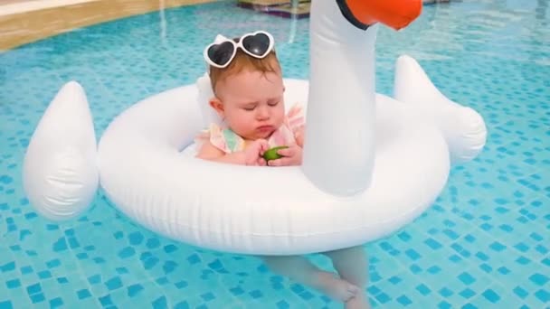 Barnet svømmer i bassenget i en sirkel. Selektivt fokus. – stockvideo
