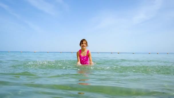 Un niño salpica agua en el mar. Enfoque selectivo. — Vídeos de Stock