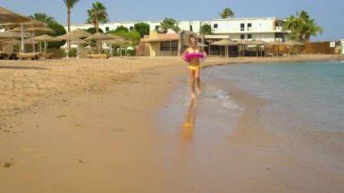 Bir çocuk sahile doğru koşuyor. Seçici odak.