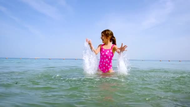 Et barn sprøjter vand på havet. Selektivt fokus. – Stock-video