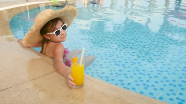 To dítě pije koktejl v bazénu. Selektivní zaměření. — Stock video