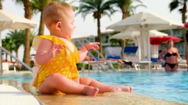 Bebé se juega con agua cerca de la piscina. Enfoque selectivo. — Vídeos de Stock