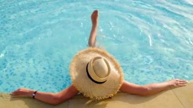 Havuzdaki şapkalı kadın. Seçici odak.