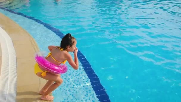 Barnepigen hopper i poolen. Selektivt fokus. – Stock-video