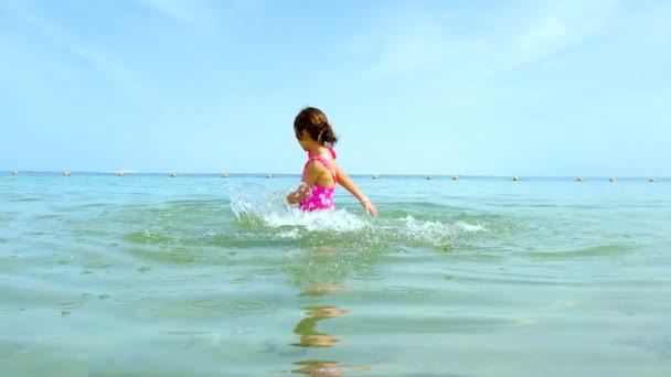 한 아이 가 바다에 물을 뿌리고. 선택적 초점. — 비디오