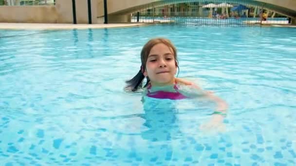 A menina nada na piscina. Foco seletivo. — Vídeo de Stock