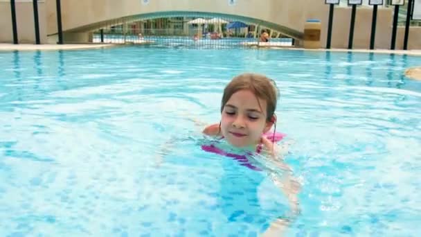 Ένα κοριτσάκι κολυμπάει στην πισίνα. Επιλεκτική εστίαση. — Αρχείο Βίντεο