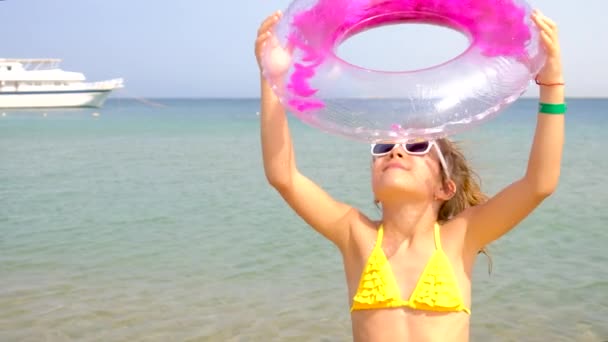 Et barn på stranden holder en svømning cirkel. Selektivt fokus. – Stock-video