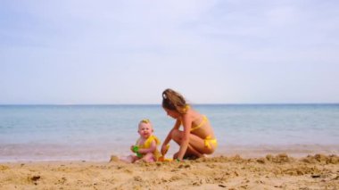 Çocuklar kumsalda kumla oynarlar. Seçici odak.