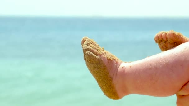 Małe nóżki w piasku na plaży. ukierunkowanie selektywne. — Wideo stockowe