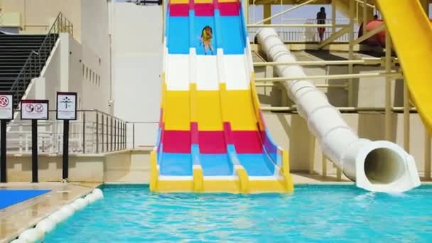 Un enfant descend des toboggans du parc aquatique. focus sélectif. — Video