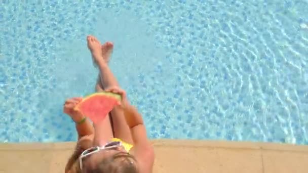 Kind isst Wassermelone in der Nähe des Pools. Selektiver Fokus. — Stockvideo