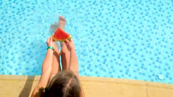 Criança comendo melancia perto da piscina. foco seletivo. — Vídeo de Stock