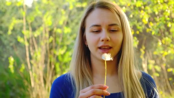 Menina soprando uma flor de dente de leão. Foco seletivo. — Vídeo de Stock