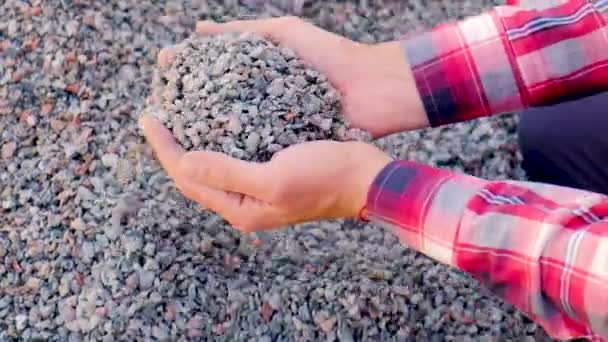 A man holds small rubble in his hands. Selective focus. — Stock Video