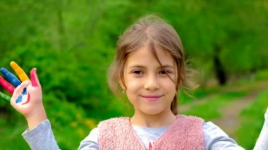 Çocuk boyalı bir gülümseme tutuyor. Seçici odak.