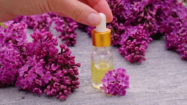 Óleo essencial de lilás e extrato em uma pequena garrafa. Foco seletivo. — Vídeo de Stock